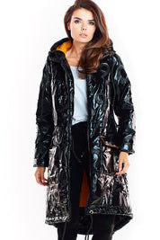 Woman wearing Morvanna oversized glossy insulated coat in black with contrasting lining, showcasing urban layering fashion.