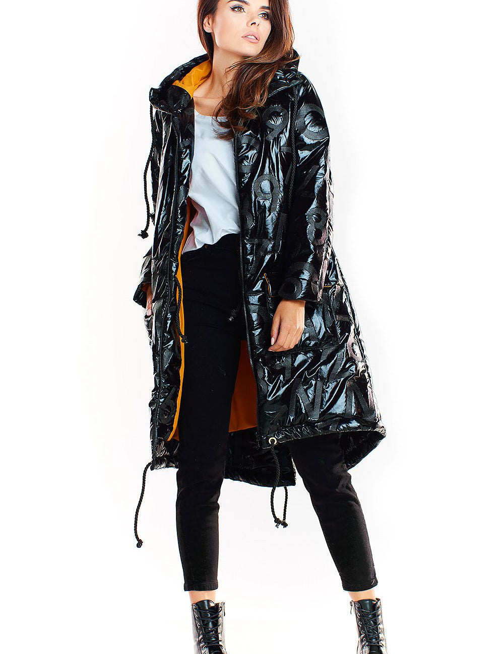 Woman wearing Morvanna oversized glossy insulated coat with contrasting lining, styled for urban layering, deep black finish.
