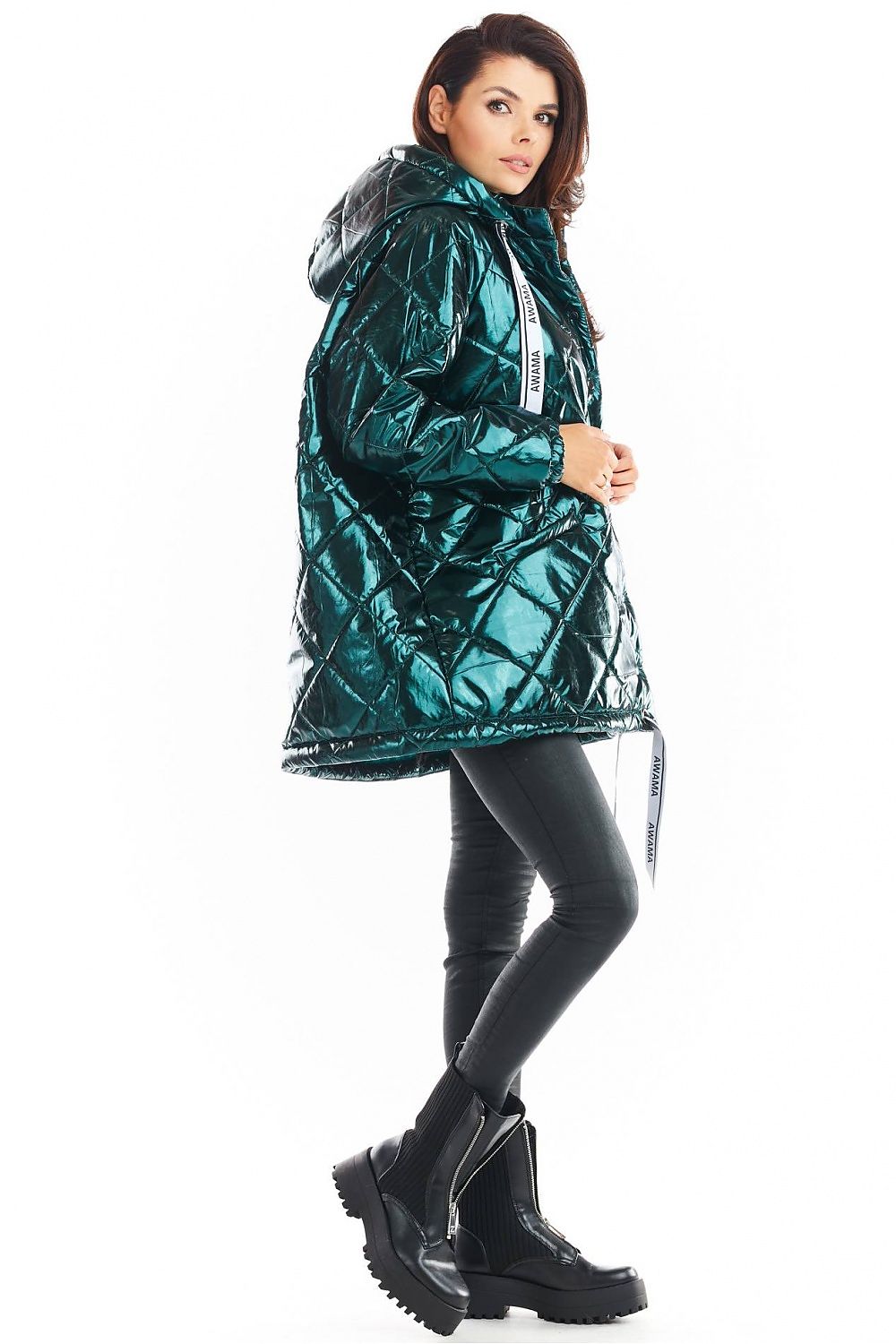 Amawa Oversized Quilted Hooded Jacket in teal, featuring snap fastening, large hood, and decorative logo tape, styled with black pants and boots.