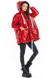 Woman wearing red Amawa Oversized Quilted Hooded Jacket with decorative logo tape and front pockets, showcasing a stylish casual look.