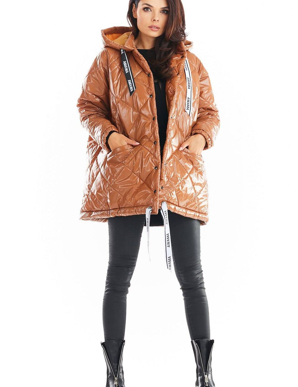 Amawa Oversized Quilted Hooded Jacket with logo tape, snap fastening, and front pockets, worn by model in black pants and boots.