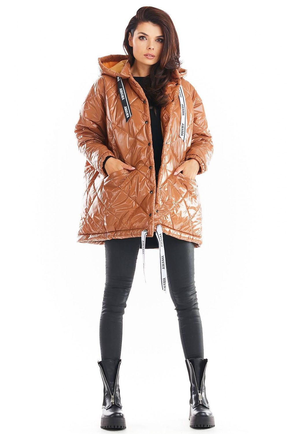 Amawa Oversized Quilted Hooded Jacket with logo tape, snap fastening, and front pockets, worn by model in black pants and boots.