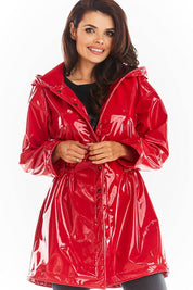 Model wearing red Orlavenne knee-length vinyl hooded coat with buttons, flared hem, and drawstring waist.
