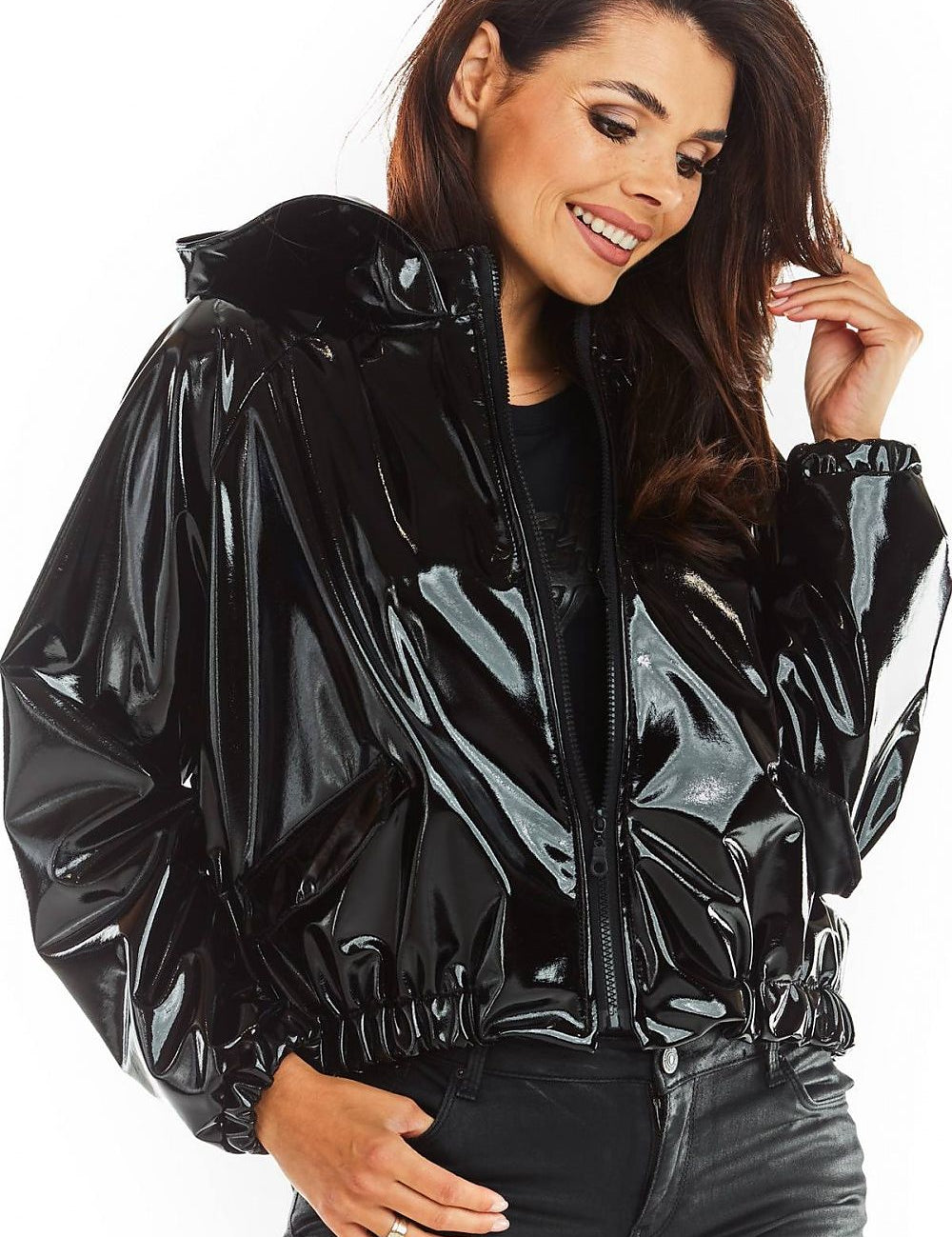 Woman wearing black Nerivelle short vinyl hooded jacket with ribbed cuffs and zip front, showcasing street style and practicality.