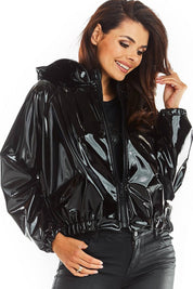Woman wearing black Nerivelle short vinyl hooded jacket with ribbed cuffs and zip front, showcasing street style and practicality.