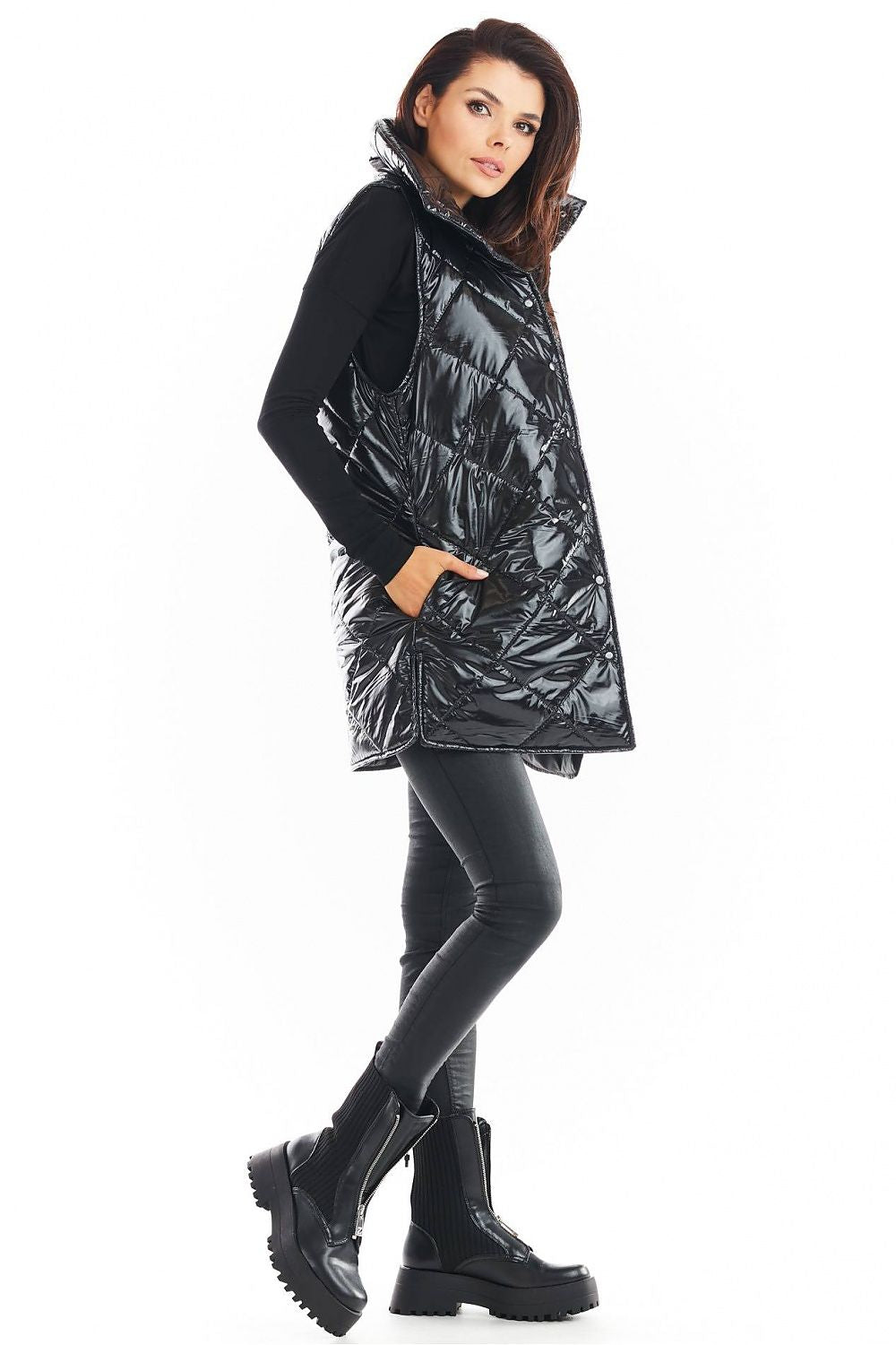 Woman wearing black Clarewyn quilted high-collar gilet vest, styled with leather pants and boots, highlighting fall fashion versatility.