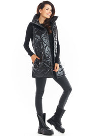 Woman wearing Clarewyn quilted high-collar gilet vest in black, showcasing stylish autumn layering with casual boots and leggings.