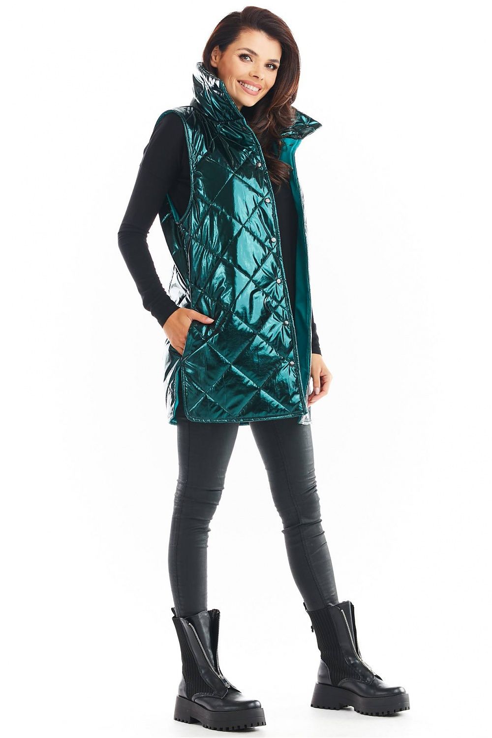 Woman wearing Clarewyn Quilted High-Collar Gilet, emerald color, styled with black leggings and boots, showcasing the autumn essential vest.