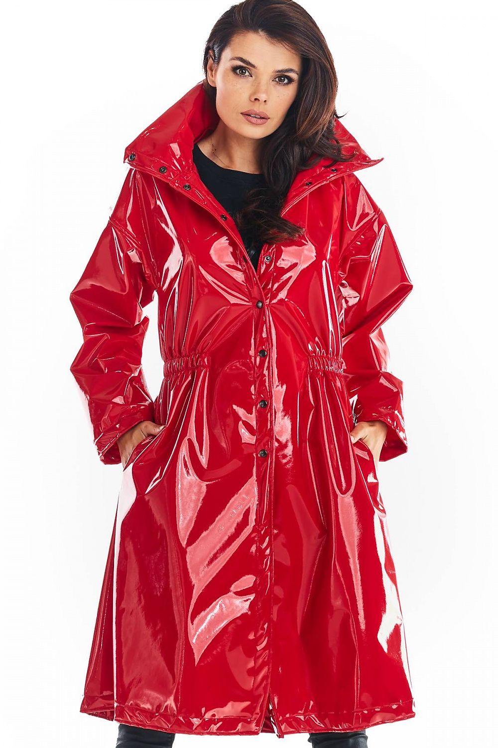 Model wearing Marveena knee-length red vinyl raincoat with high collar and flared hem, showcasing bold style and practicality.