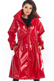 Model wearing Marveena knee-length red vinyl raincoat with high collar and flared hem, showcasing bold style and practicality.