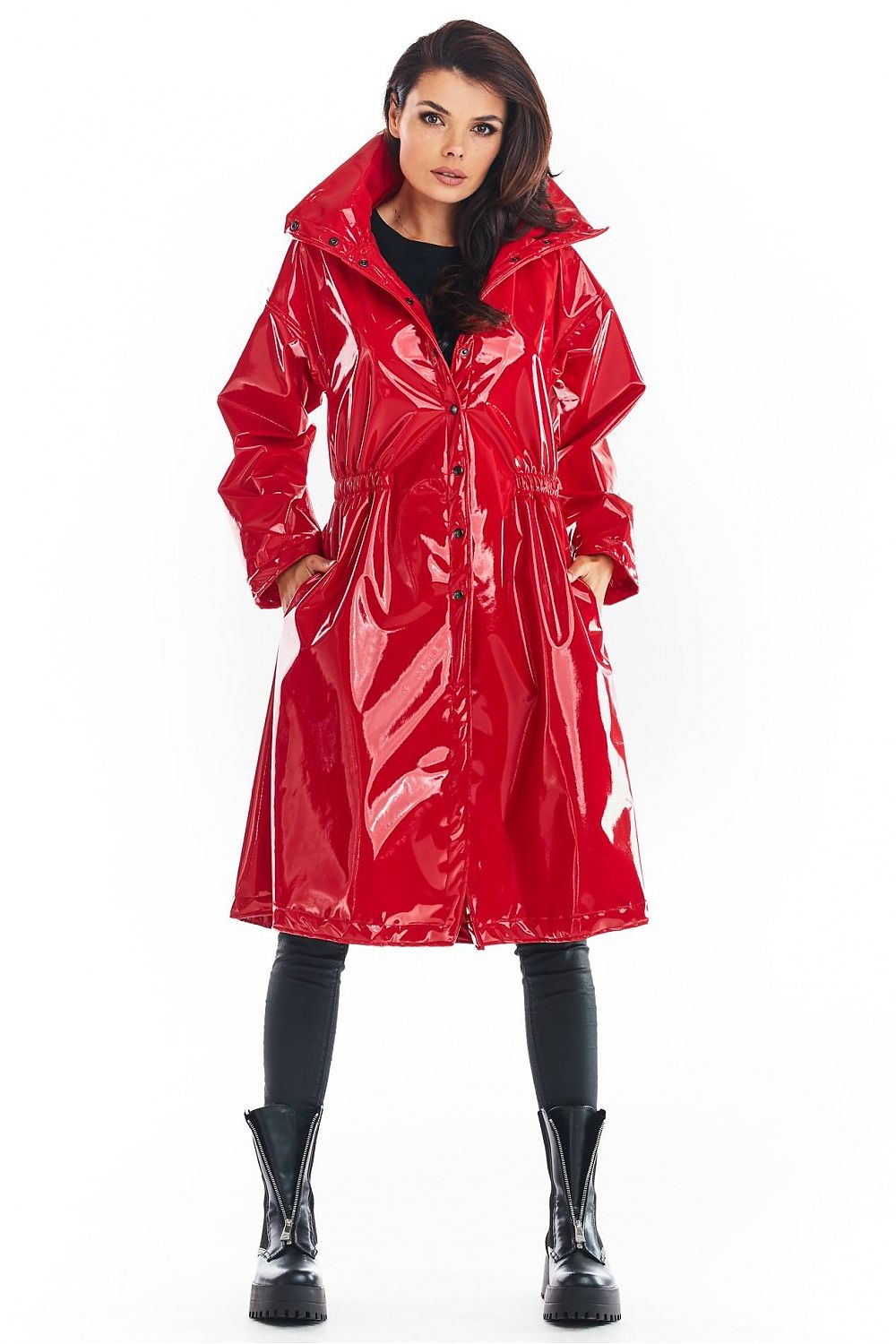 Woman wearing a red Marveena knee-length vinyl raincoat with high collar and straight sleeves, styled for modern weather protection.