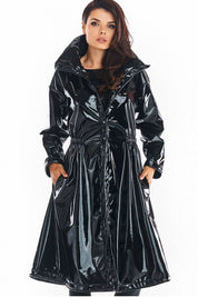 Woman wearing Marveena knee-length black vinyl raincoat with high collar and flared hem.