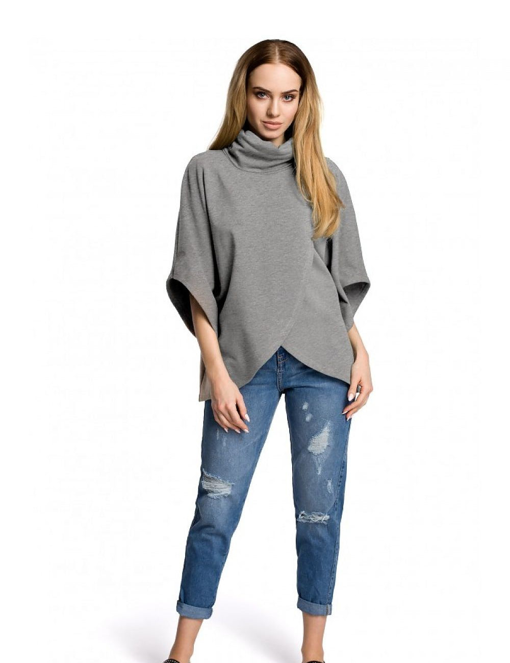 Model wearing Tiraven Knit Turtleneck Blouse in gray, paired with distressed jeans. Cozy and casual fashion statement for cooler days.