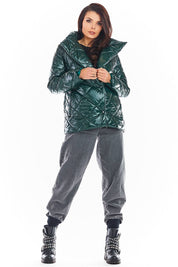 Model wearing Zavielle quilted jacket with stand collar in emerald green, paired with grey pants and studded boots, showcasing stylish warmth.