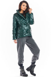 Woman wearing a green Zavielle quilted jacket with a stand collar, paired with gray pants and black studded boots.