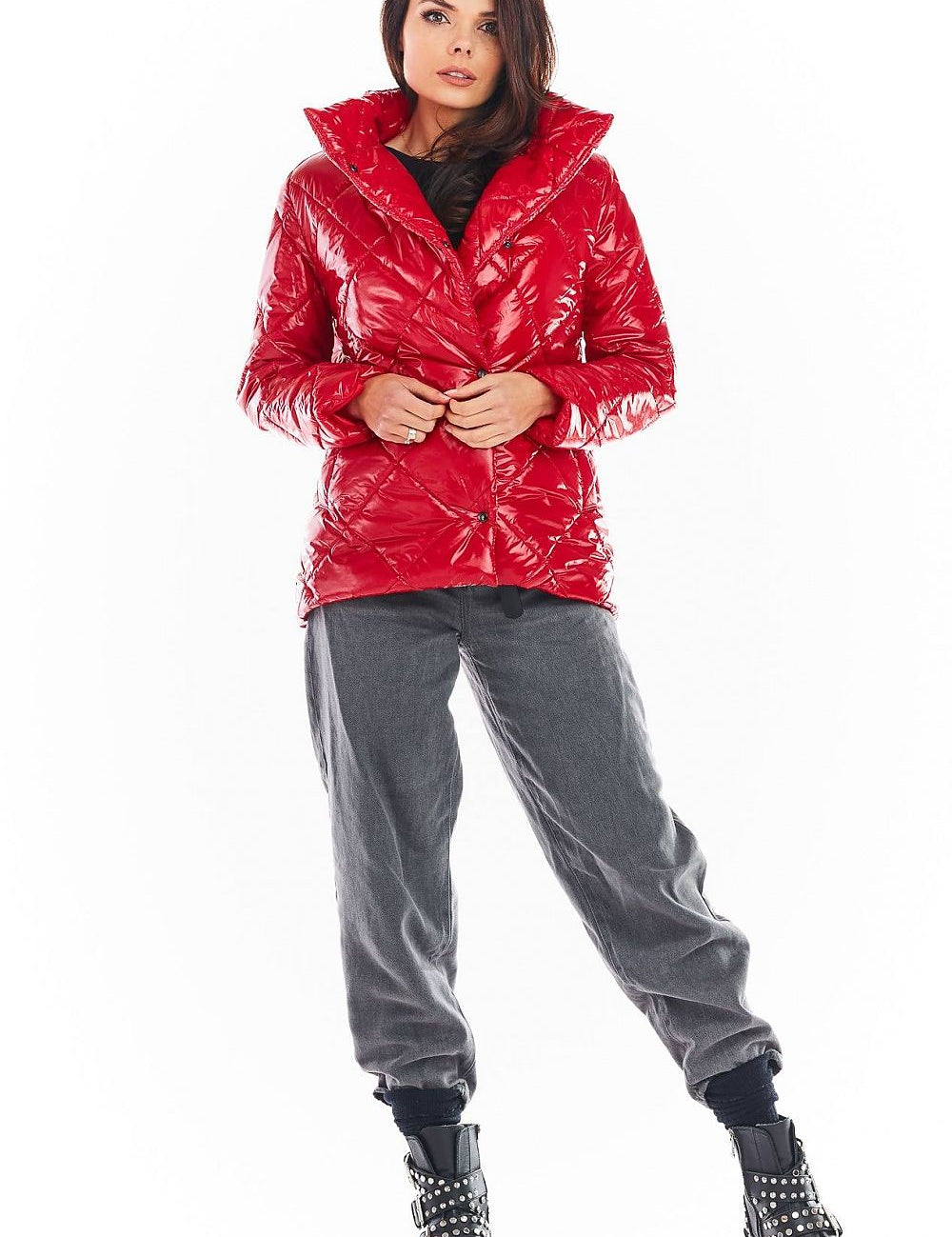 Woman wearing red Zavielle quilted jacket with stand collar, buttoned front, and black studded boots.