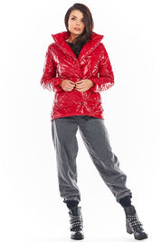 Woman wearing red Zavielle quilted jacket with stand collar, buttoned front, and black studded boots.