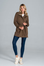 Model wearing Dervelle Short Quilted Belted Coat in brown, featuring front patch pockets and a classic collar, paired with jeans and sneakers.