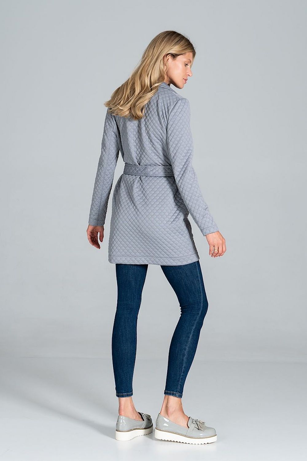 Woman wearing Dervelle short quilted belted coat with classic collar and patch pockets, styled with jeans and loafers.