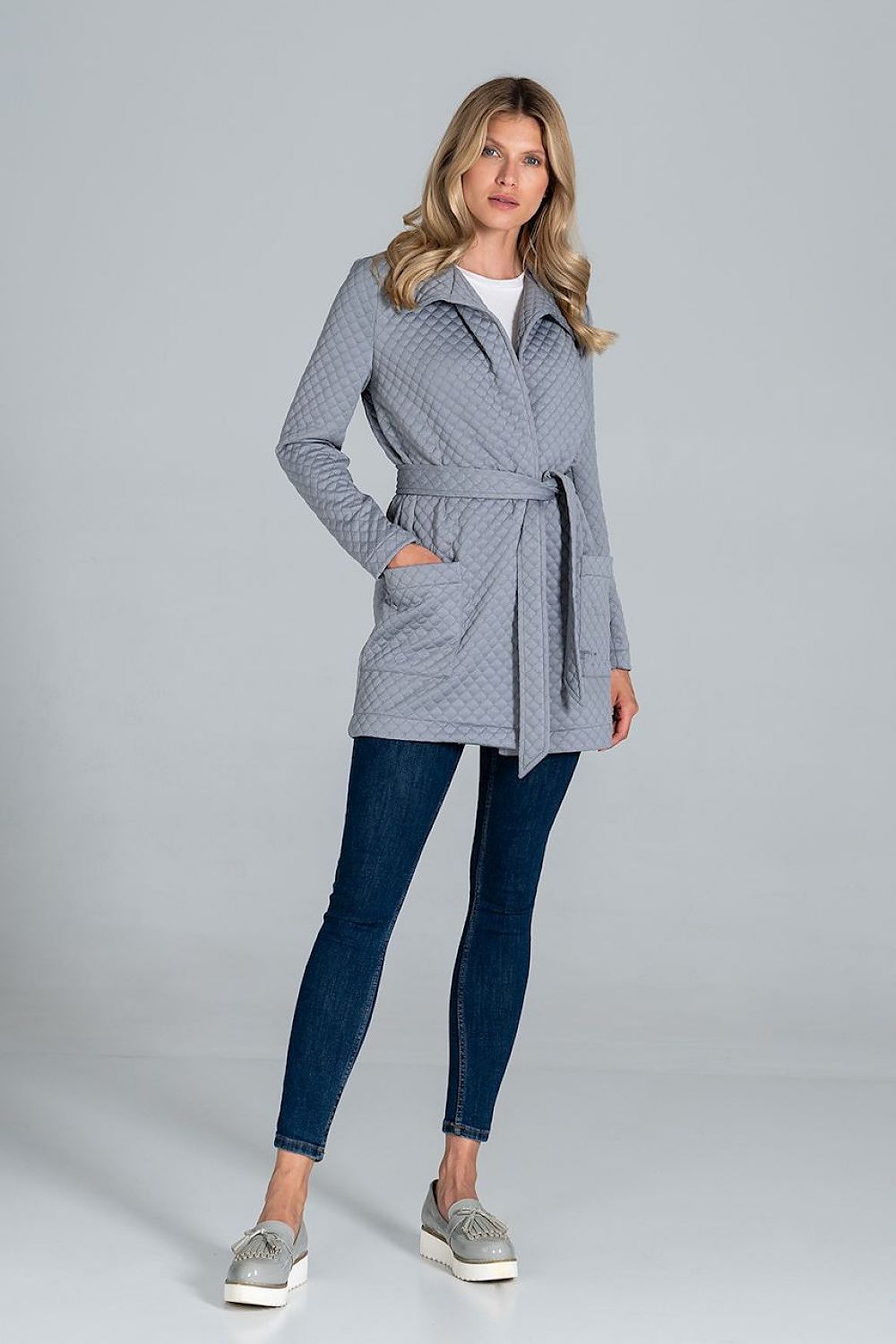 Woman wearing Dervelle short quilted belted coat with classic collar and patch pockets, ideal for layering in transitional seasons.