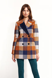 Woman wearing Maelvara checked double-breasted coat with notched collar and side pockets, showcasing elegant autumn style.