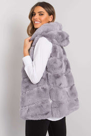 Woman wearing Yndarelle hooded quilted gilet vest in light gray, demonstrating soft structure and versatility for layering.