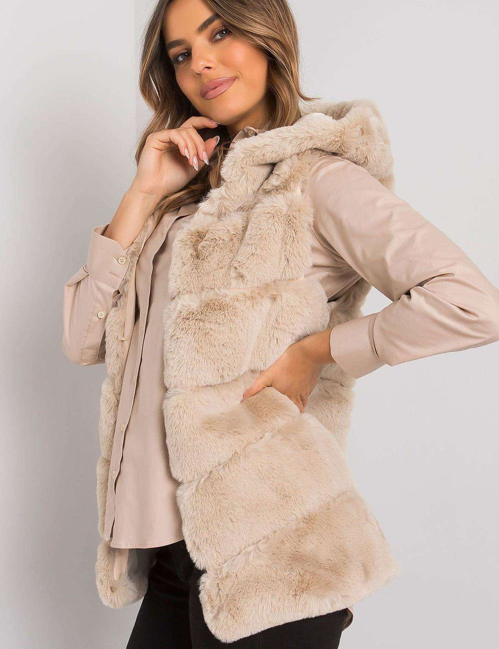Woman wearing a beige hooded quilted gilet vest, showcasing a stylish and cozy look for versatile layering in changing seasons.