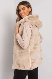 Woman wearing a plush, hooded, quilted gilet vest in beige, casually styled for layering, highlighting cozy and stylish outerwear.