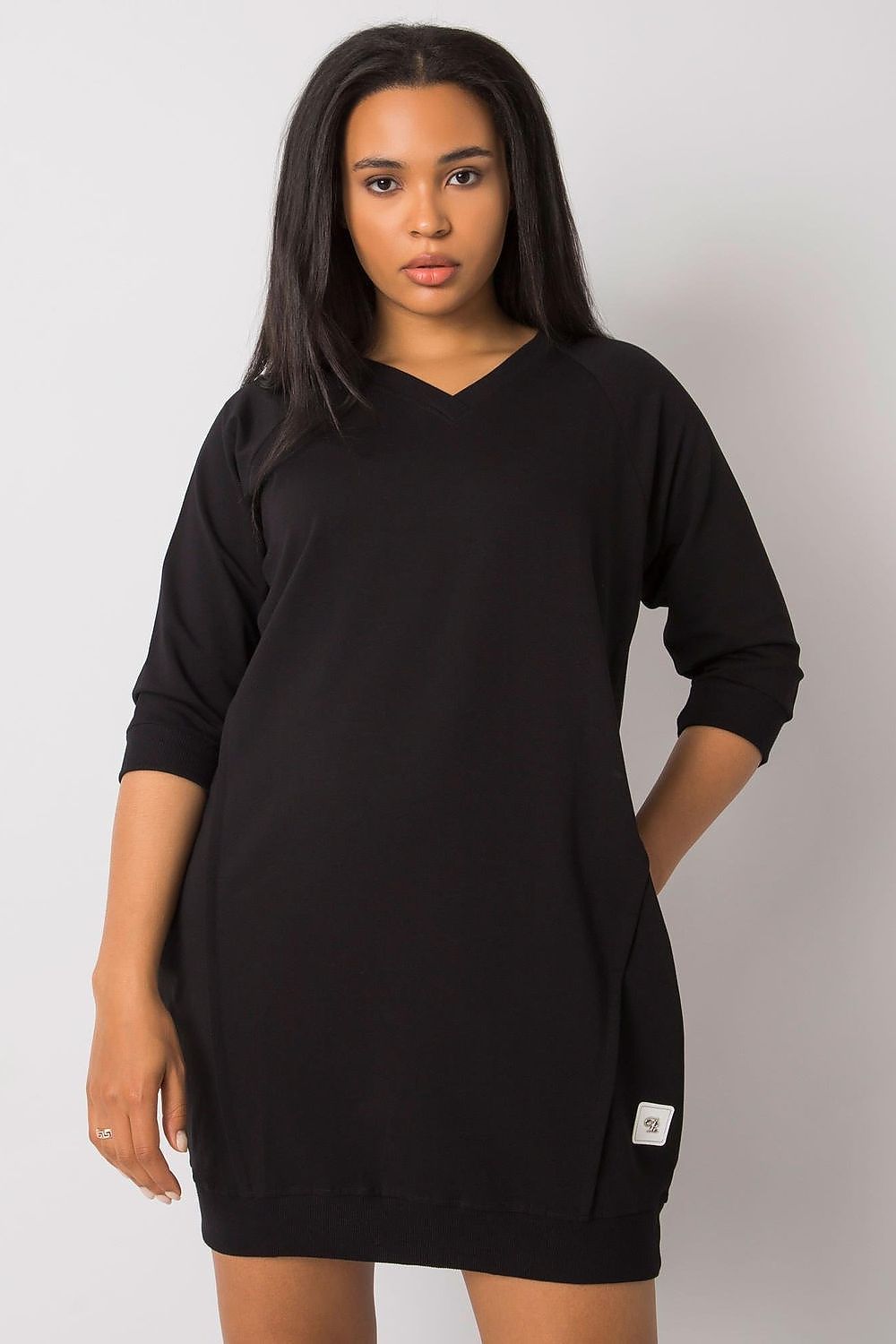 Woman wearing a black plus size Velissia cotton pocket dress with 3/4 sleeves, showcasing classic silhouette and practical side pockets.
