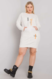 Plus Size Erelvine Pocket Day Dress in white with long sleeves, front pocket, and casual fit, worn by model with black boots.