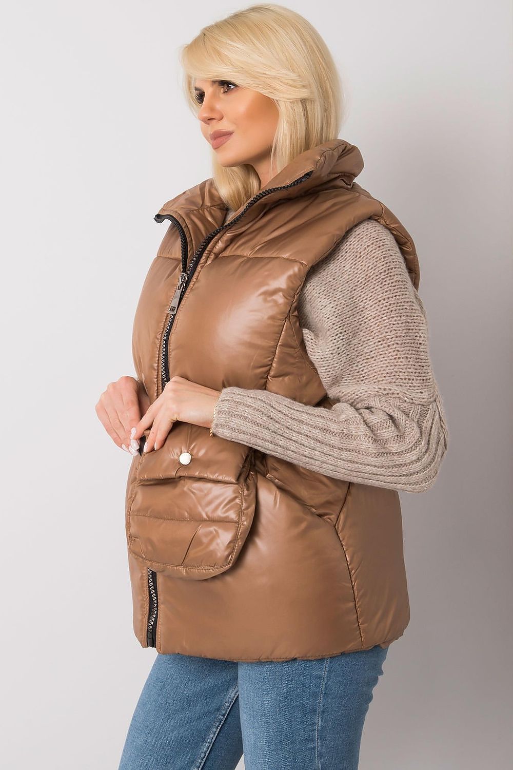 Woman wearing a Calveris Belted Lined Zip Gilet, showcasing a stylish brown sleeveless vest with a front zip and side pockets.