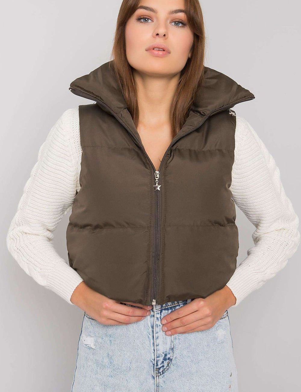 Woman wearing Trevano Khaki Zip Vest layered over a white sweater, featuring a concealed hood and full-length zip closure.