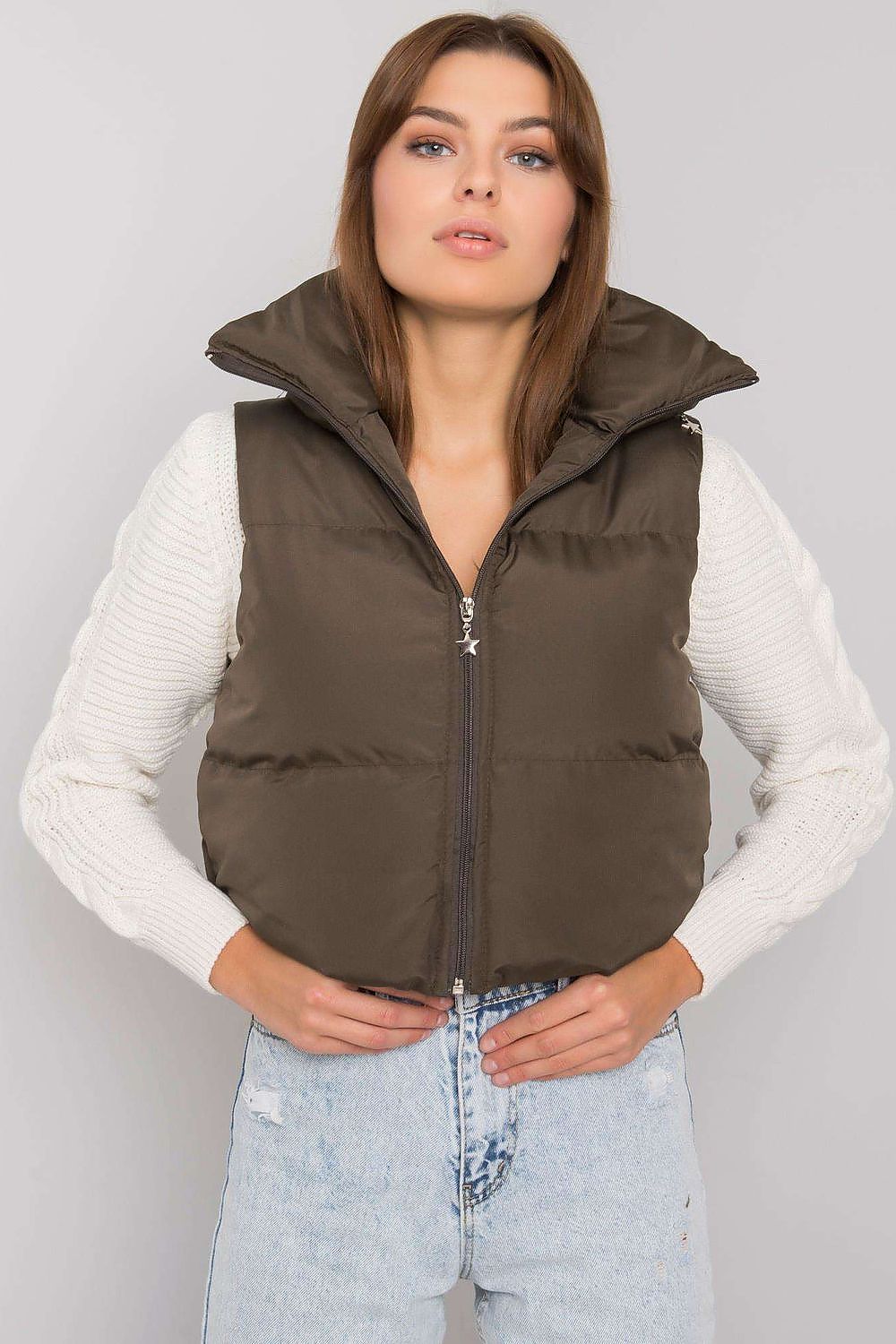 Woman wearing Trevano Khaki Zip Vest layered over a white sweater, featuring a concealed hood and full-length zip closure.