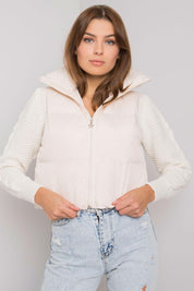 Woman wearing a khaki zip vest with a concealed hood and lightweight design, ideal for layering and versatile wear.