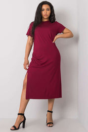 Woman wearing a plus size Serelinne casual summer dress in red, featuring short sleeves and side slit, paired with black heels.