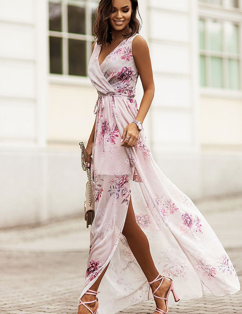 Woman wearing a floral plus size chiffon maxi dress with V-neckline and side slit, showcasing elegant summer fashion on a city street.