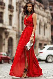 Woman wearing a red plus size chiffon maxi dress with V-neck, elastic waistband, and side slit, posing on a city street with a clutch.