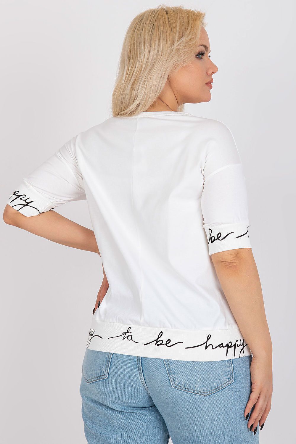 Back view of model wearing Plus Size Virella Cotton Blouse with decorative inscriptions on sleeves and hemline, round neckline, casual fit.