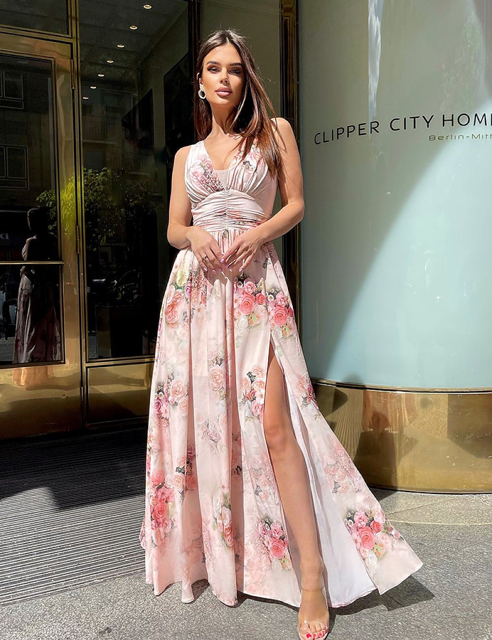 Plus size Fiorenze floral maxi dress with soft neckline and leg slit, worn outdoors for an elegant summer look, city backdrop.