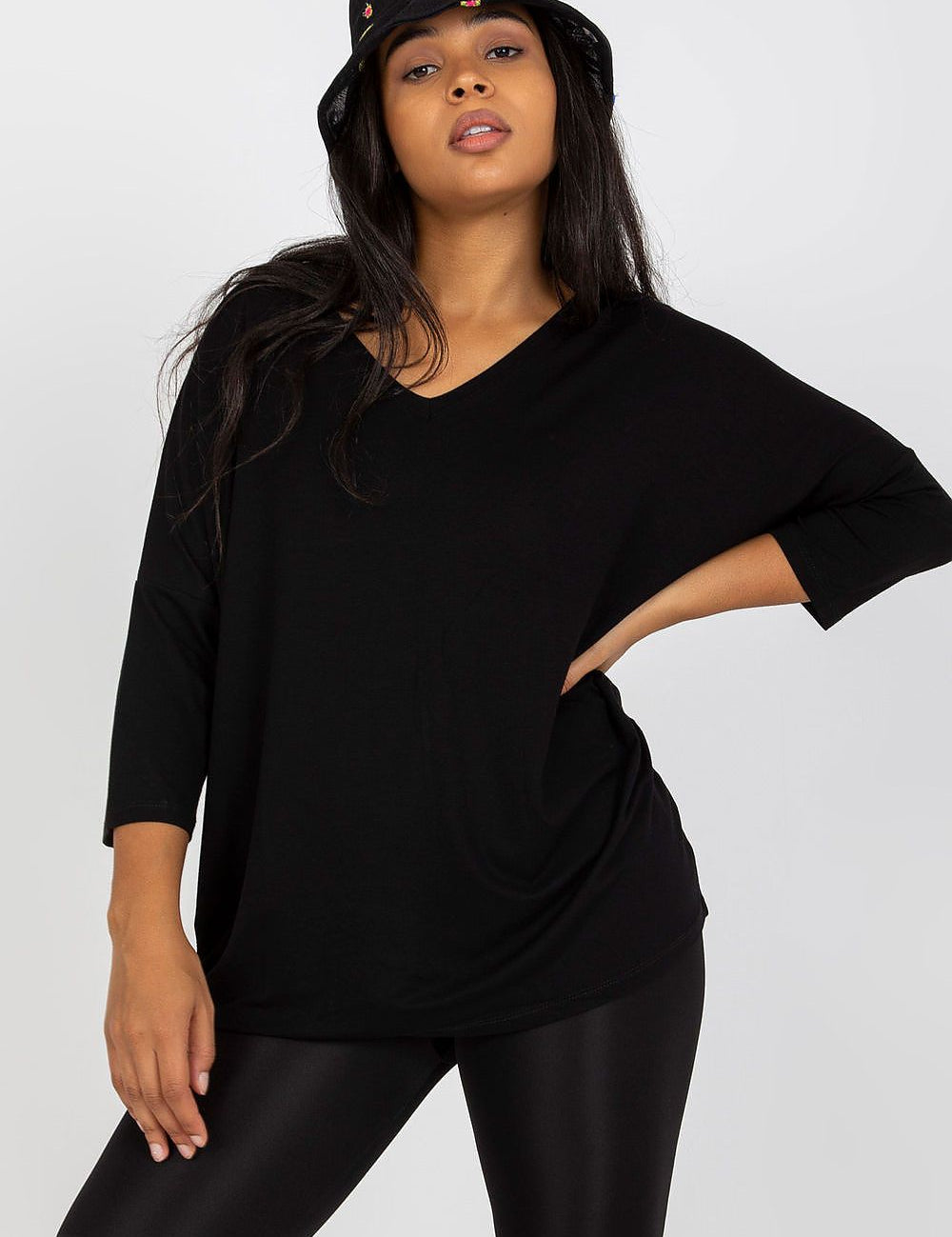 4 sleeve blouse with sweetheart neckline and black shorts, posing confidently with hand on hip.