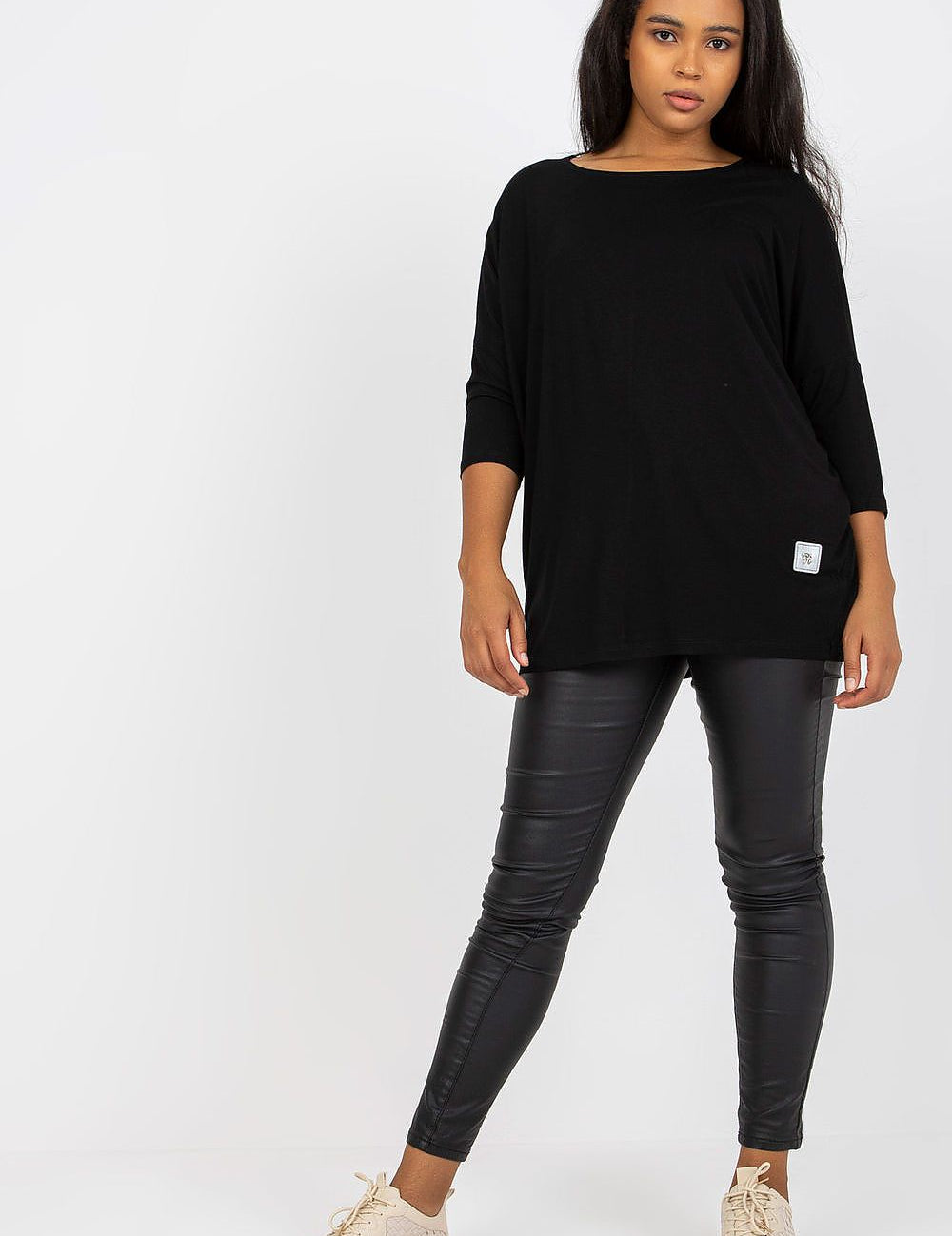 4 sleeves, paired with black leggings and beige sneakers.
