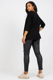 Woman wearing black plus size Bellarie cotton blouse with 3/4 sleeves, showcasing relaxed fit and gentle boat neckline.