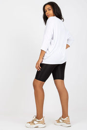 Woman wearing Plus Size Bellarie Cotton Blouse with 3/4 sleeves, showcasing a casual, comfortable fit with black shorts.