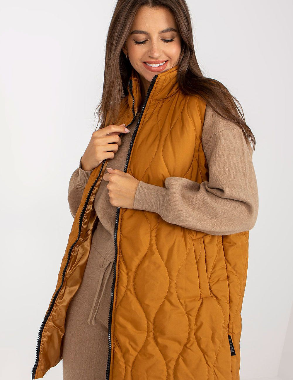 Woman wearing Syverelle Quilted Gilet Vest in mustard, showcasing minimalist silhouette and sleek zipper, perfect for layering.