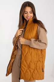 Woman wearing Syverelle Quilted Gilet Vest in mustard, showcasing minimalist silhouette and sleek zipper, perfect for layering.
