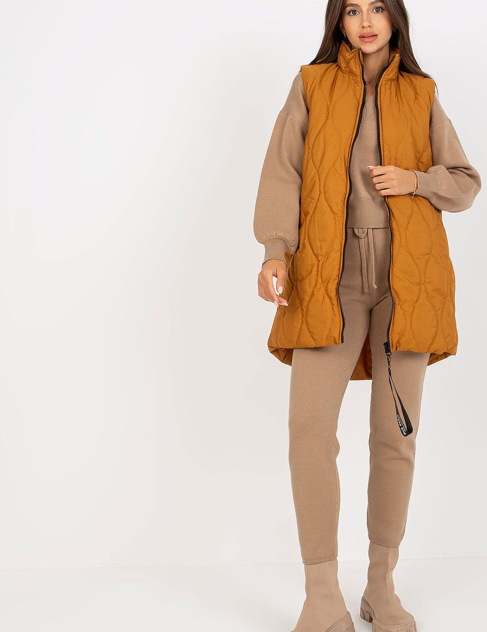 Woman wearing Syverelle quilted gilet vest with sleek zipper, minimalist style in mustard color, perfect for layered outfits.