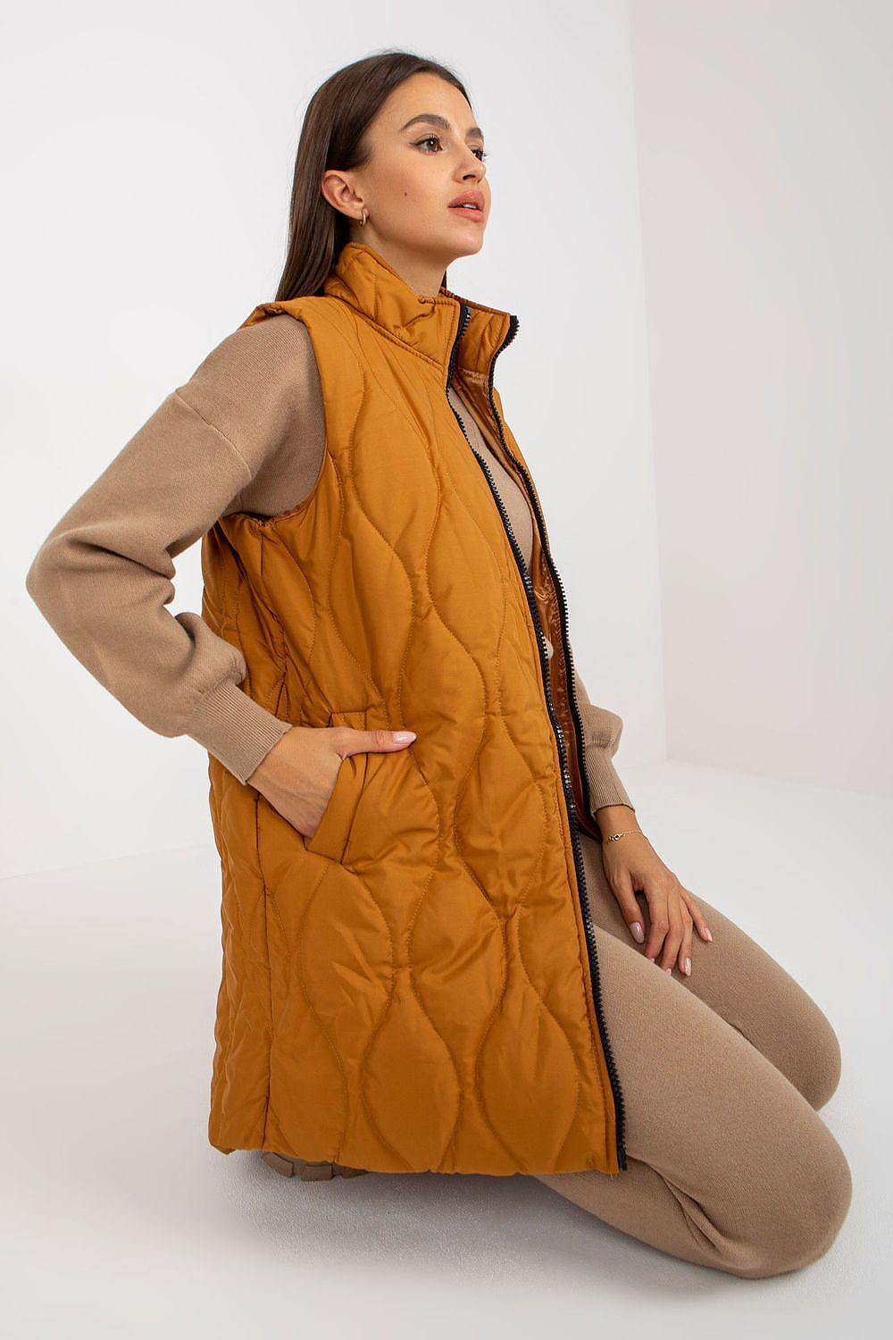 Woman modeling Syverelle quilted gilet vest with sleek front zipper, showcasing minimalist design and side slip pockets for versatile layering.