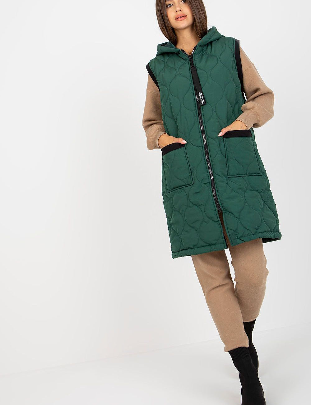 Model wearing Virethia Quilted Hooded Gilet with front pockets, showcasing stylish warmth for outfits. Ideal for transitional weather.