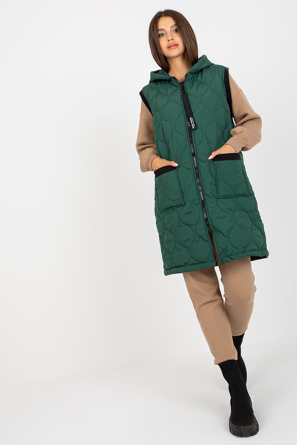 Model wearing Virethia Quilted Hooded Gilet with front pockets, showcasing stylish warmth for outfits. Ideal for transitional weather.