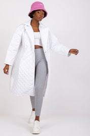 Woman wearing Orlianne quilted transitional coat, white with side slip pockets, paired with grey leggings and pink bucket hat.